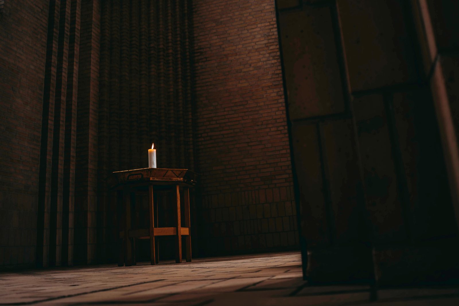 A single lit candle in a quiet, empty church interior